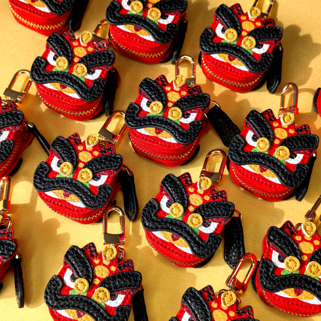 Collection of red and black decorative items resembling red and black lion dance guan yu head on a golden background